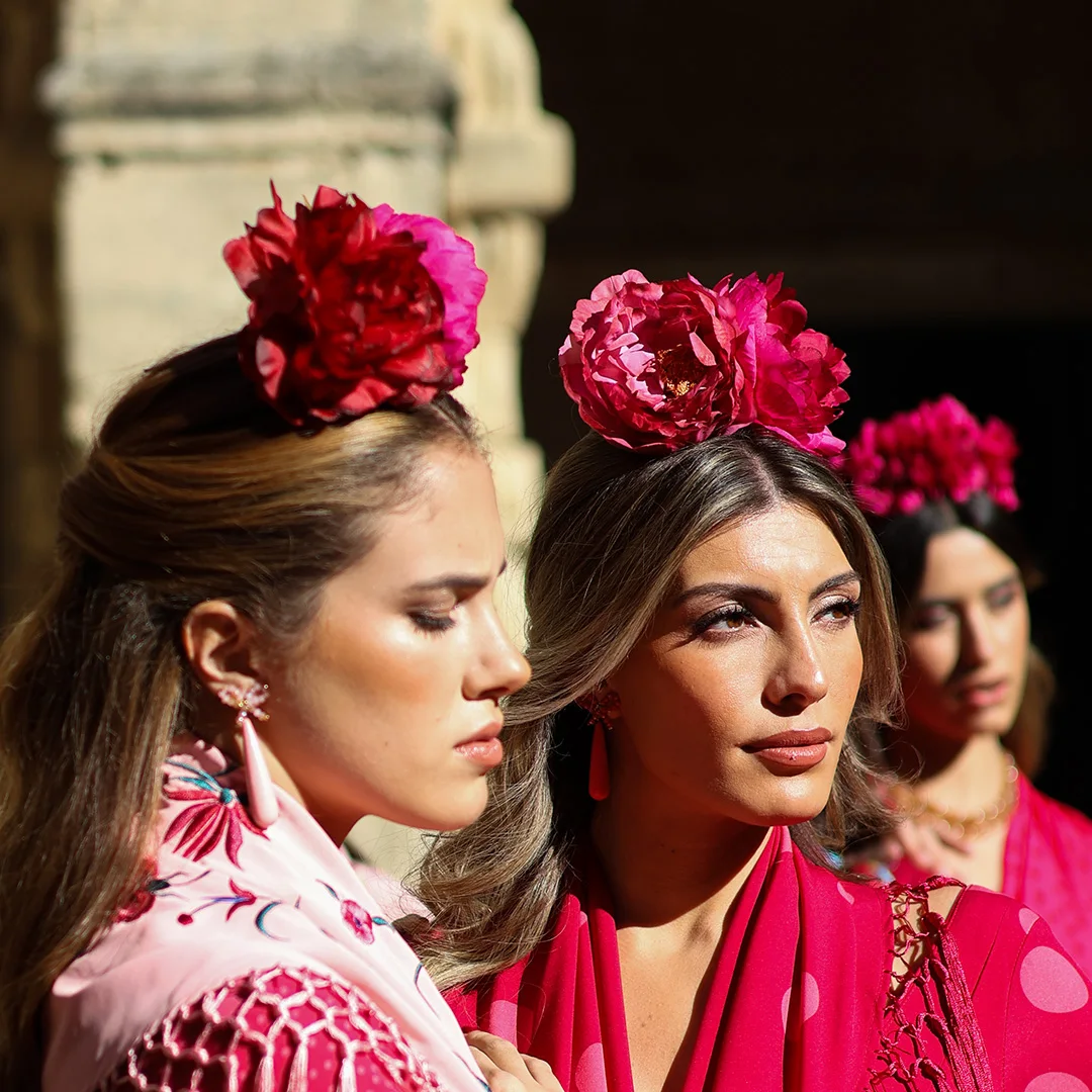 Flores flamencas en tonos fucsia para el cabello, moda flamenca 2026, complemento tradicional andaluz, tendencia pasarela