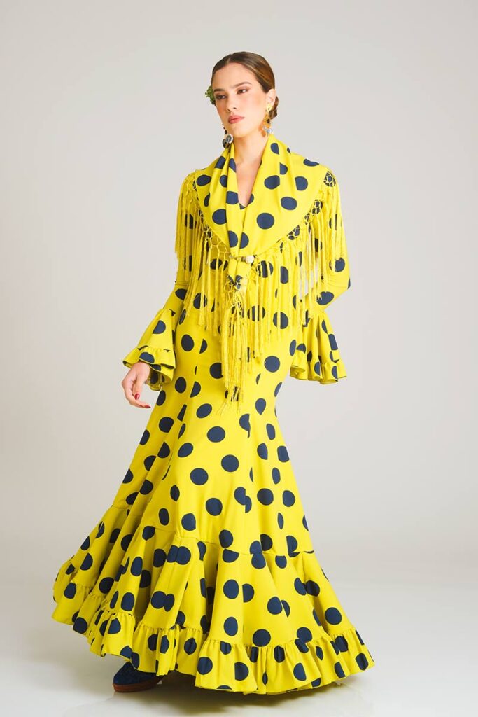 Vestido de flamenca confeccionado en un llamativo tono verde manzana con grandes lunares en contraste, presentado con un corte sirena que estiliza la figura y falda rematada en volantes para un acabado con movimiento y carácter.