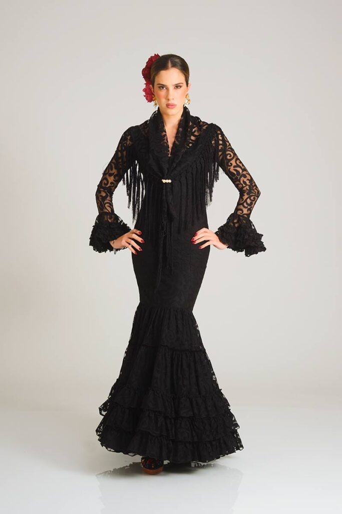 Vestido de flamenca artesanal en encaje negro con corte sirena entallado y falda de volantes en cascada. Diseño de alta costura.