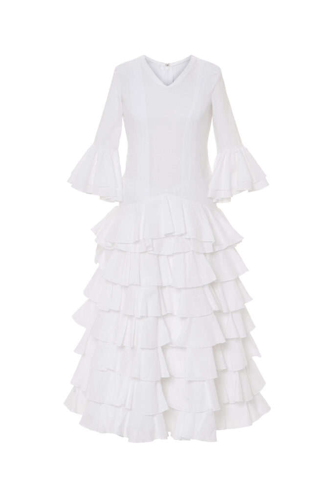 Precioso vestido de flamenca infantil en color blanco, confeccionado con un diseño clásico de cuerpo ajustado y una voluminosa falda de múltiples volantes escalonados, ideal para lucir un estilo tradicional y festivo en cualquier romería o feria