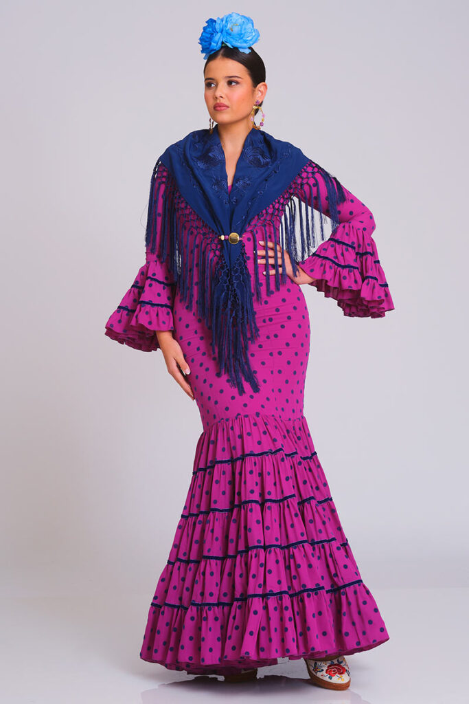 Traje de flamenca fucsia con lunares oscuros, diseño entallado con volantes en falda y mangas, ideal para ferias y eventos