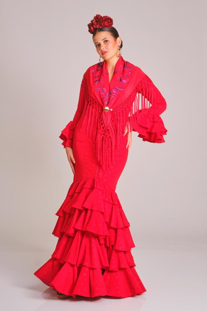 Traje de flamenca rojo con lunares, diseño entallado con múltiples volantes en falda y mangas, ideal para ferias y eventos andaluces