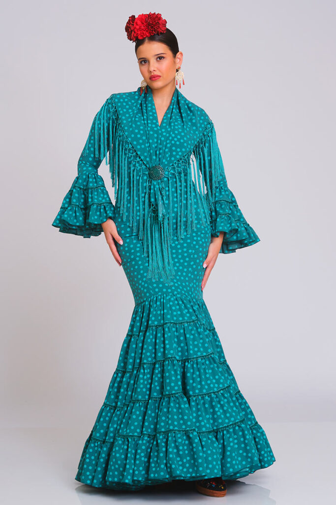 Traje de flamenca color verde petróleo con lunares, diseño entallado con volantes en falda y mangas, incluye mantoncillo con flecos a juego