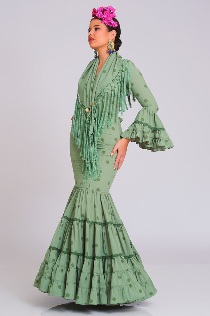 Traje de flamenca verde suave con estampado de lunares, diseño entallado con volantes en la falda y mangas, incluye mantoncillo con flecos a juego