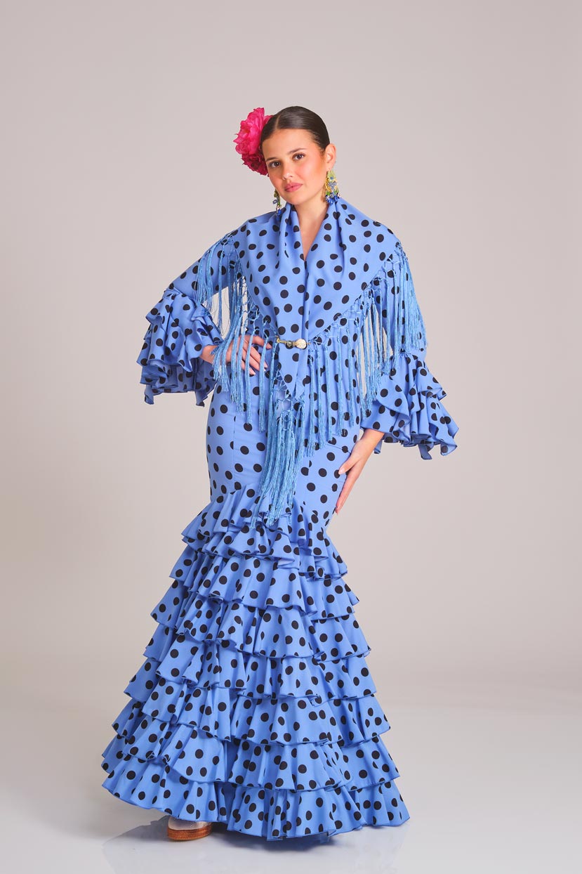Traje de flamenca azul claro con lunares negros, diseño de volantes en cascada y mantoncillo coordinado, ideal para ferias y eventos