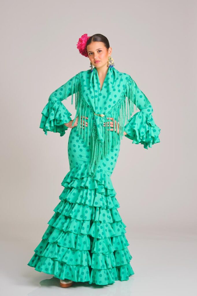 Traje de flamenca verde con lunares, falda de volantes y mantoncillo a juego, diseño elegante para ferias y romerías