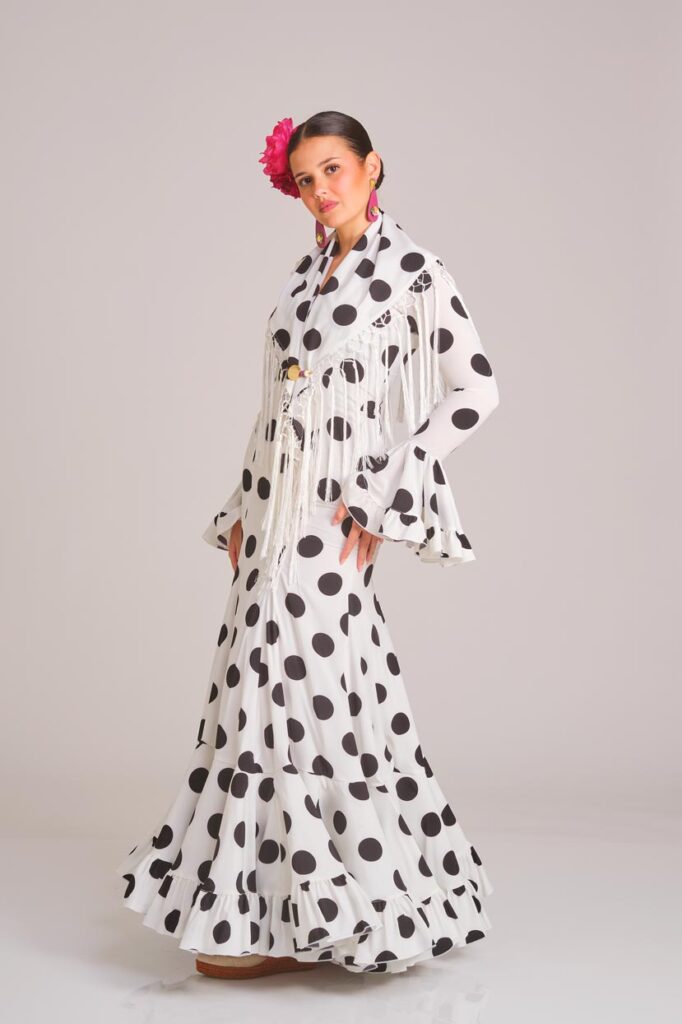 Traje de flamenca blanco con lunares negros de corte clásico, con volantes y mantoncillo, ideal para ferias y romerías