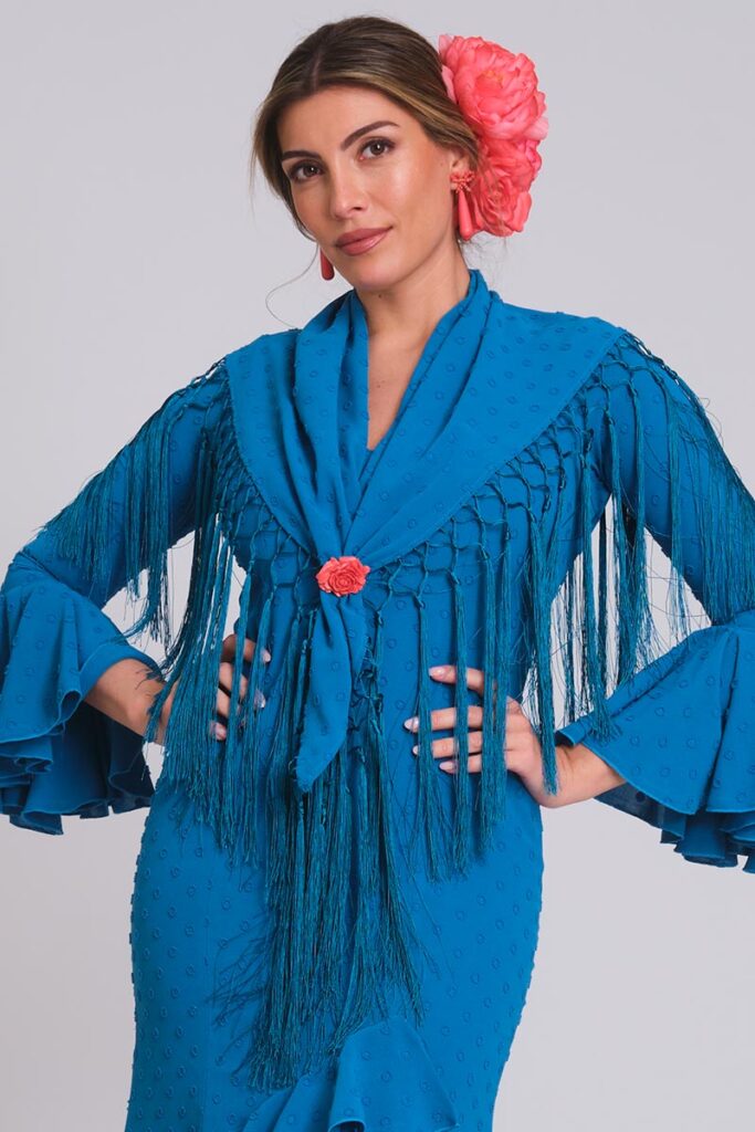 Vestido de flamenca azul Francia de plumeti con relieve, mangas de volantes múltiples y mantoncillo de flecos largos azulina.