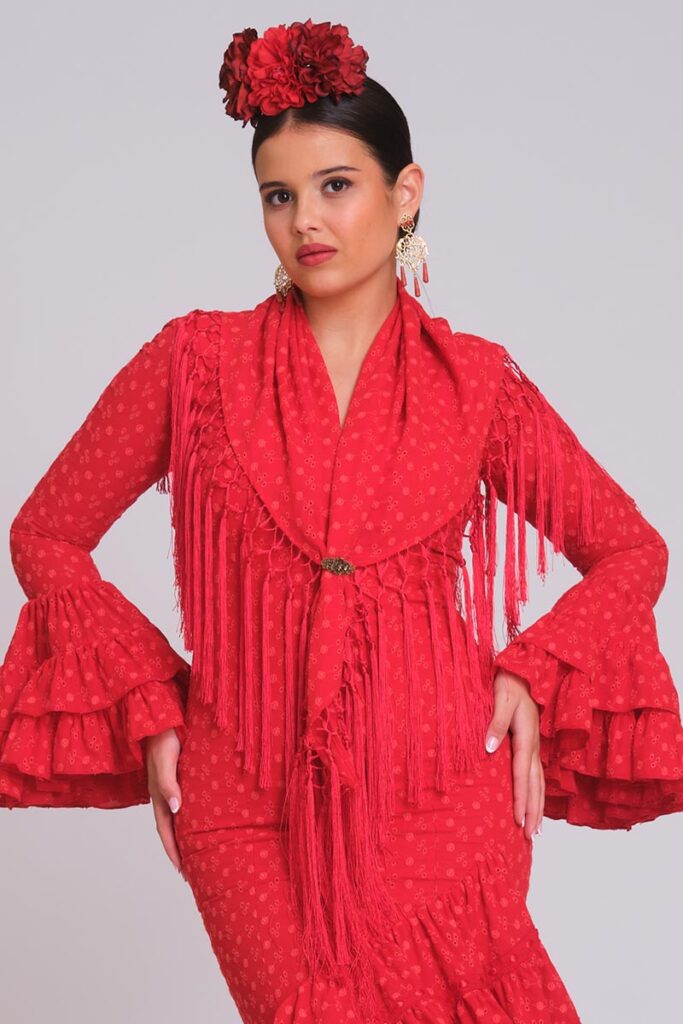 Vestido de flamenca rojo de tejido perforado calado, mangas de volantes múltiples y mantoncillo de flecos largos rojo pasión.
