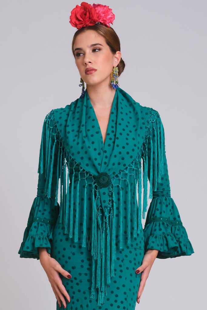 Vestido de flamenca verde con lunares negros, mangas de volantes con encaje y mantoncillo de flecos largos verde botella.