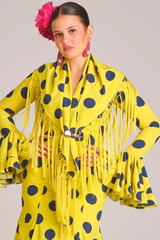 Traje de flamenca verde manzana con lunares grandes azules, mantoncillo a juego y volantes para feria