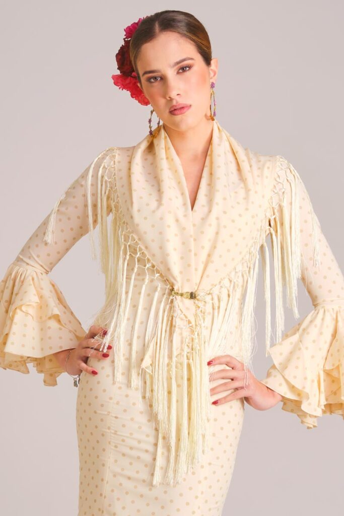 Traje de flamenca marfil con lunares beige, mantoncillo a juego y mangas de volantes para feria