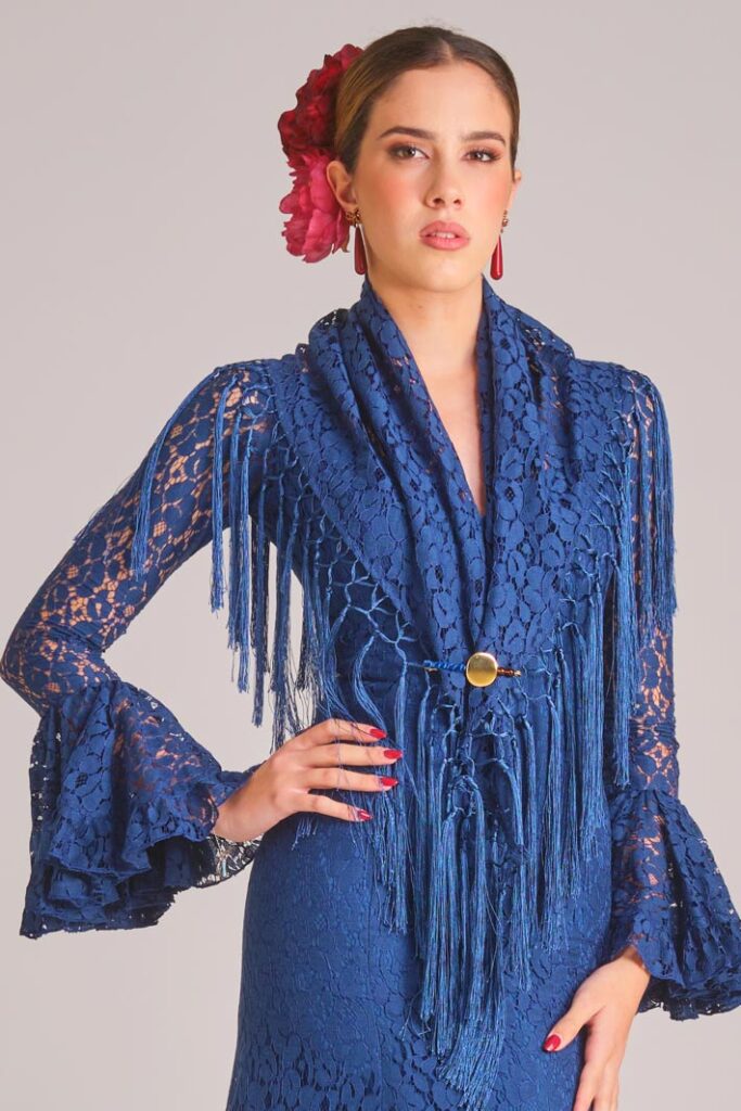 Traje de flamenca azul marino de encaje con mantoncillo a juego, flecos y mangas de volantes