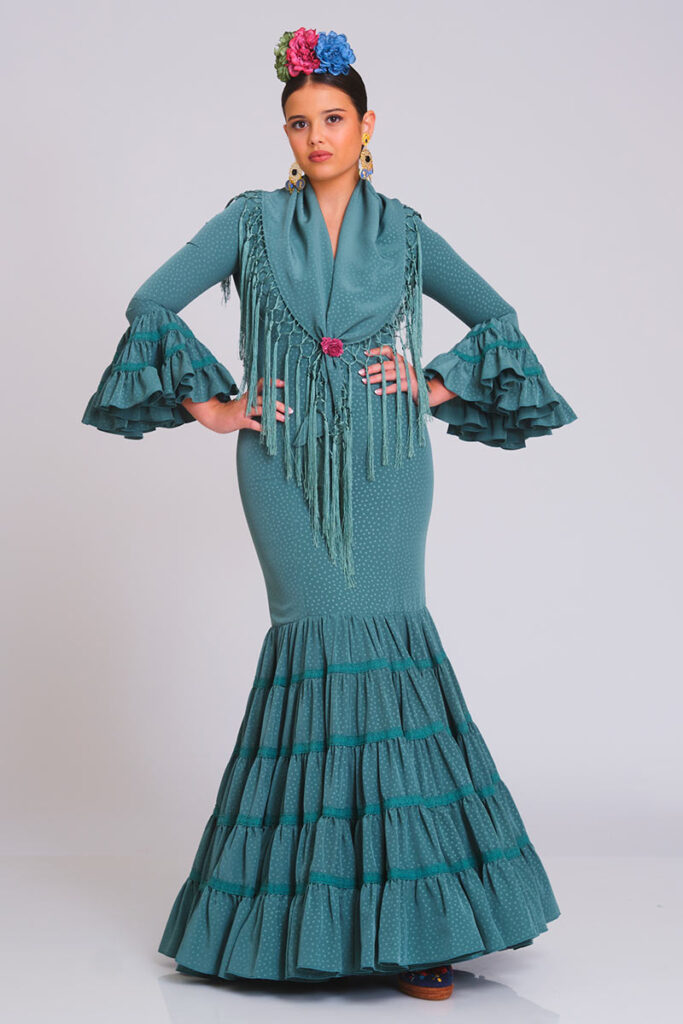 Traje de flamenca verde azulado con estampado sutil de lunares, diseño entallado con volantes en falda y mangas, ideal para ferias y eventos